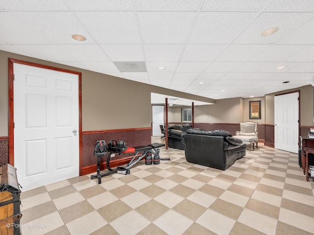 living area with recessed lighting, a wainscoted wall, and light floors