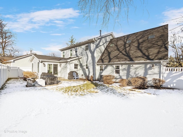 snow covered property with a fenced backyard