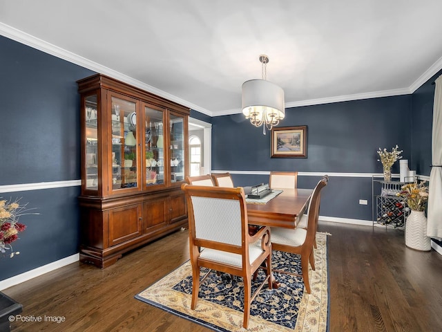 dining room featuring dark wood-style floors, ornamental molding, and an inviting chandelier