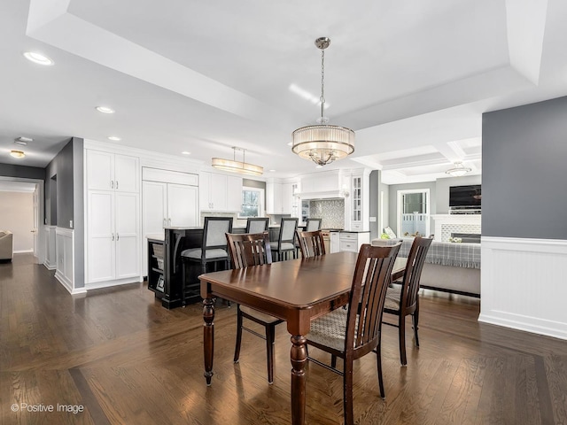 dining room with recessed lighting, a wainscoted wall, dark wood-type flooring, coffered ceiling, and a tiled fireplace