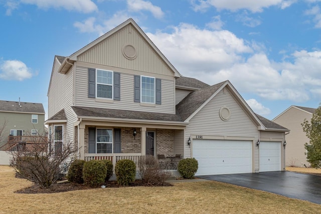 view of front of property with aphalt driveway, brick siding, a porch, an attached garage, and a front lawn