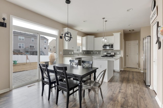 dining space with recessed lighting, wood finished floors, visible vents, and baseboards