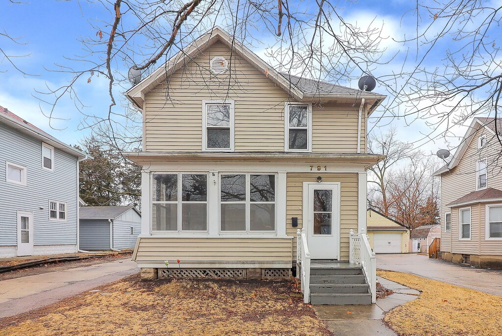 view of front facade with entry steps, an outdoor structure, and a detached garage