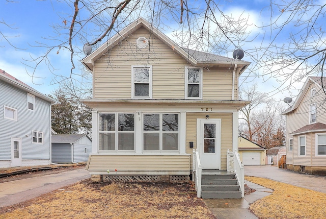 view of front facade with entry steps, an outdoor structure, and a detached garage