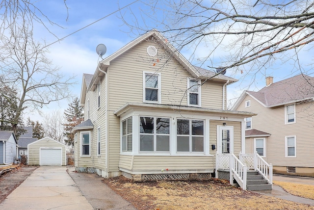 traditional home with a detached garage, an outbuilding, and concrete driveway