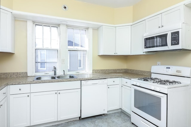 kitchen featuring white cabinets, white appliances, light countertops, and a sink