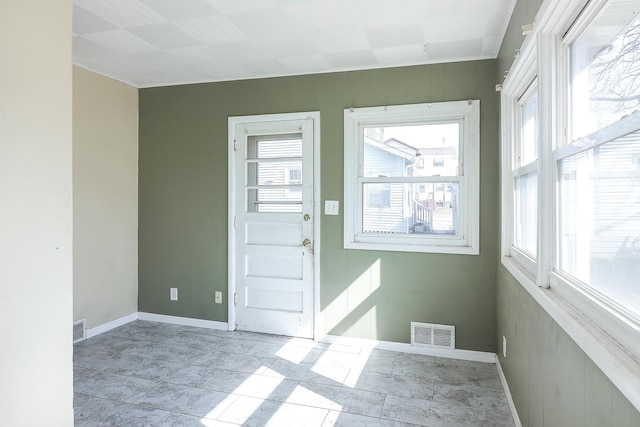 doorway to outside with visible vents, plenty of natural light, and baseboards