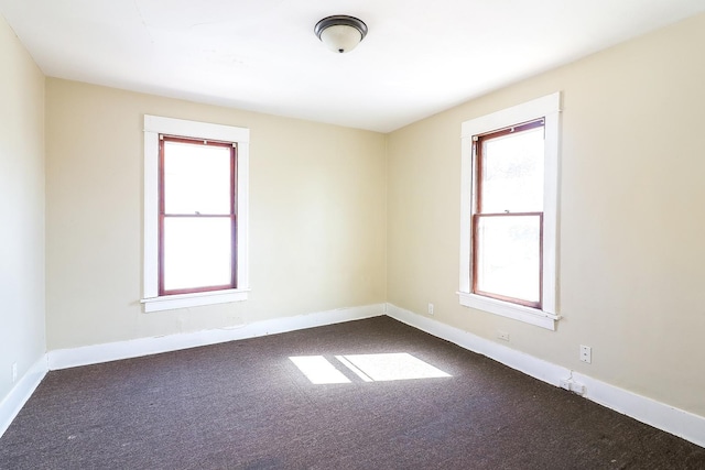 empty room with plenty of natural light, baseboards, and carpet