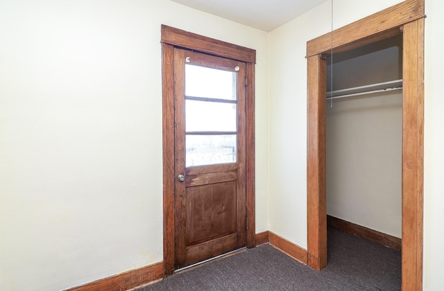 entryway with baseboards and carpet floors