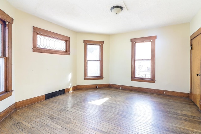 unfurnished room featuring hardwood / wood-style flooring and baseboards