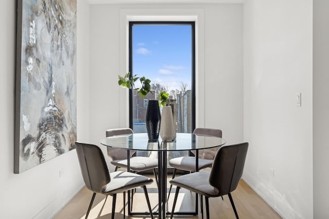 dining room with light wood-type flooring and baseboards