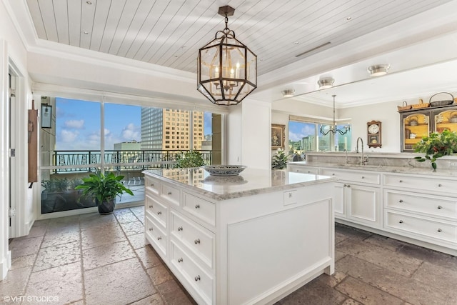 kitchen with wooden ceiling, a sink, a notable chandelier, and stone tile floors