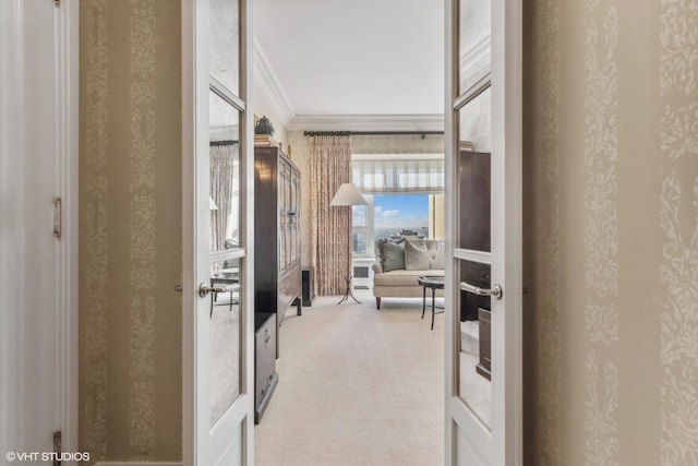 hallway with crown molding, carpet, and wallpapered walls