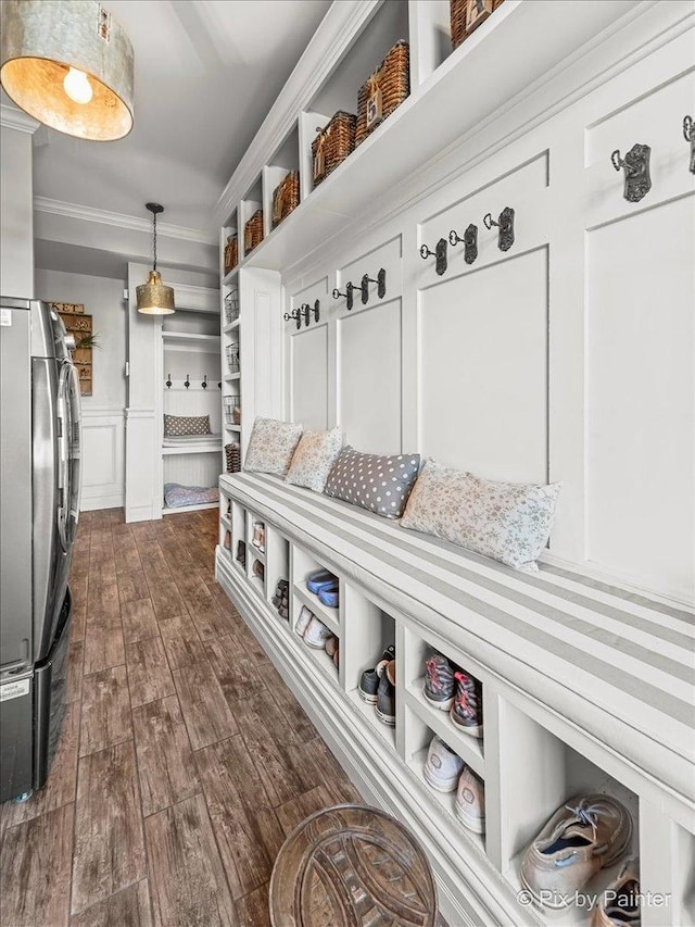 mudroom featuring dark wood-style flooring, wainscoting, crown molding, and a decorative wall