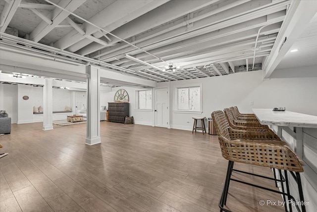 basement with baseboards and wood finished floors