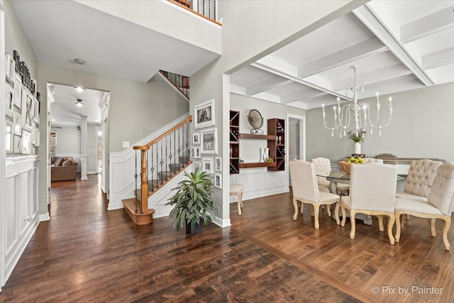 dining area with coffered ceiling, wood finished floors, stairs, beam ceiling, and a notable chandelier