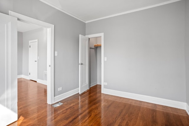 unfurnished bedroom with baseboards, a closet, wood finished floors, and crown molding