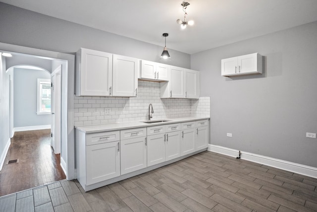 kitchen with light countertops, a sink, and white cabinetry