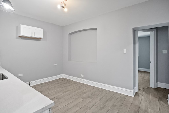 spare room featuring light wood finished floors and baseboards