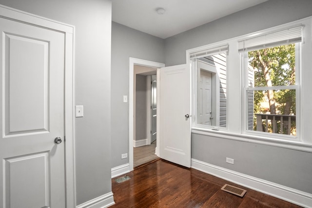 unfurnished bedroom featuring wood finished floors, visible vents, and baseboards