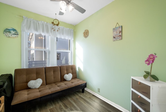 living area with wood finished floors, a ceiling fan, and baseboards