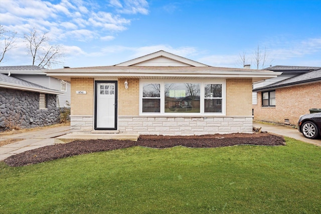 view of front of home featuring stone siding, brick siding, and a front lawn