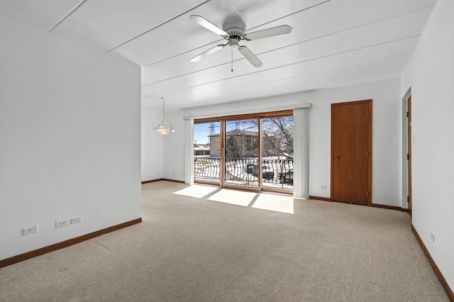 spare room with baseboards, carpet flooring, and ceiling fan with notable chandelier