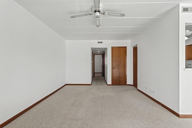 empty room featuring light carpet, visible vents, and baseboards