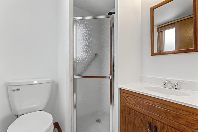 bathroom with toilet, a stall shower, and vanity