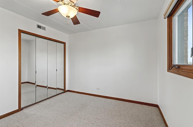 unfurnished bedroom featuring baseboards, visible vents, ceiling fan, carpet flooring, and a closet