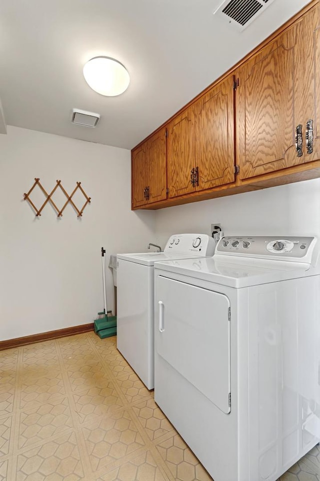 laundry area with cabinet space, visible vents, baseboards, and separate washer and dryer