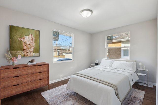 bedroom with baseboards and dark wood-style flooring