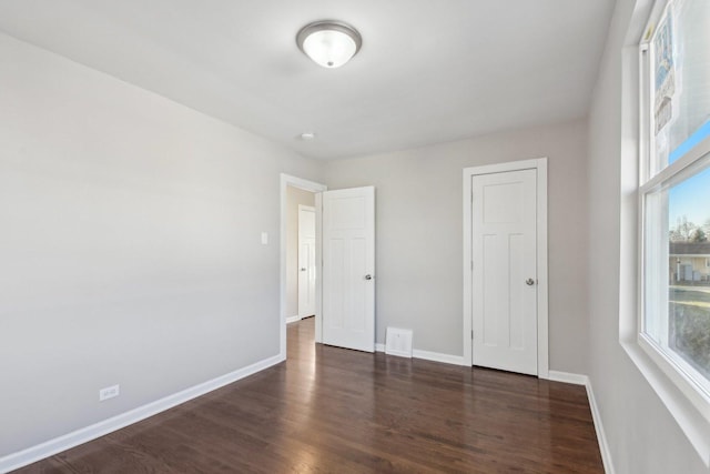 unfurnished bedroom with visible vents, baseboards, and wood finished floors