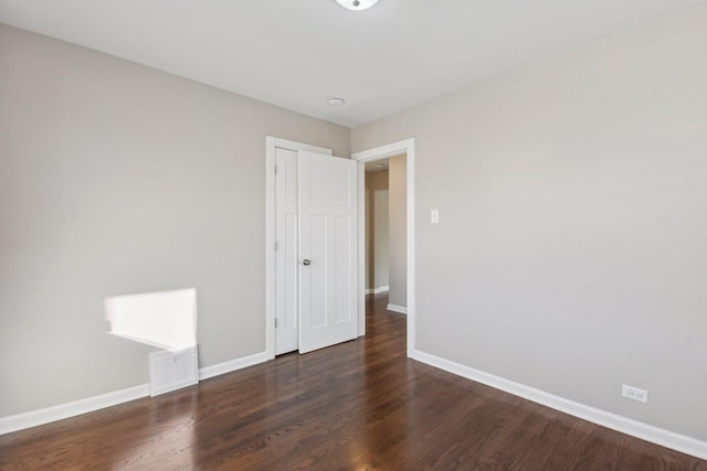 unfurnished bedroom with a closet, baseboards, and wood finished floors