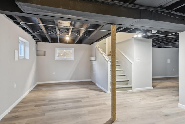 basement with stairway, baseboards, and wood finished floors