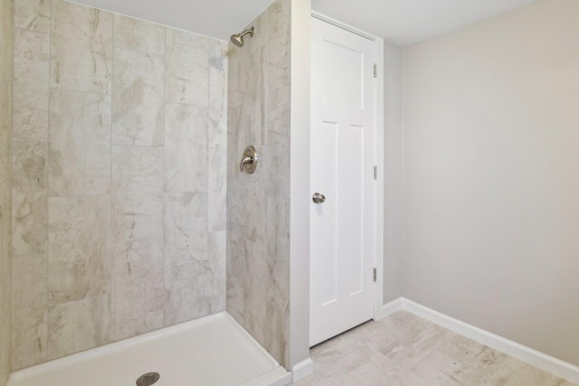 bathroom with a shower stall and baseboards