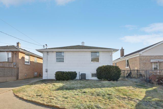 exterior space with central air condition unit, fence, and a lawn