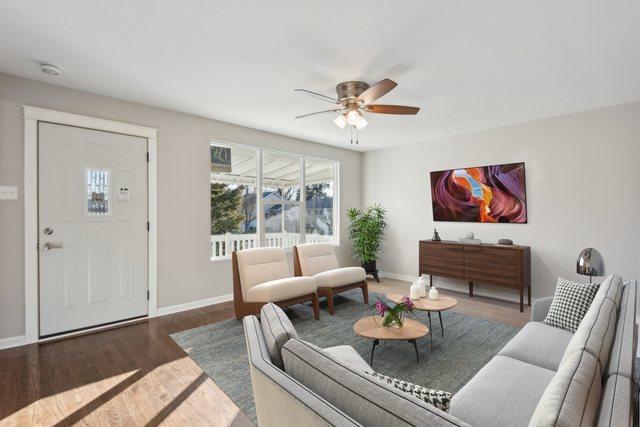 living room featuring baseboards, a ceiling fan, and wood finished floors