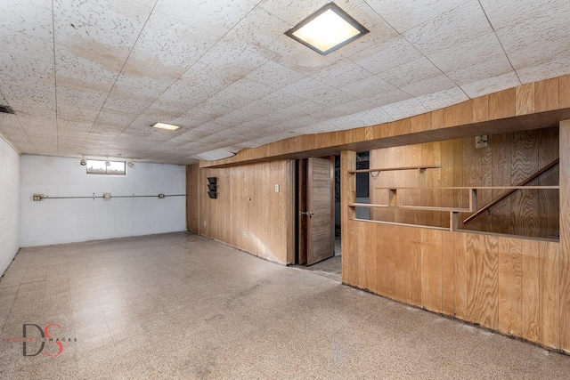 below grade area featuring wood walls and tile patterned floors