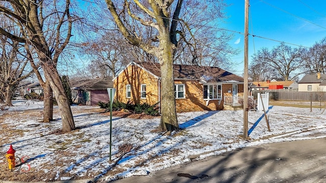 view of front of home featuring brick siding and fence