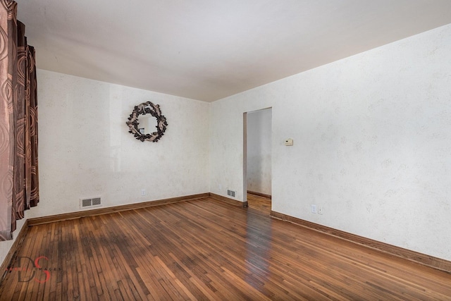 unfurnished room with visible vents and hardwood / wood-style flooring