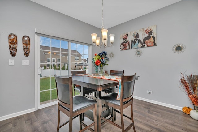 dining space featuring a notable chandelier, baseboards, and wood finished floors