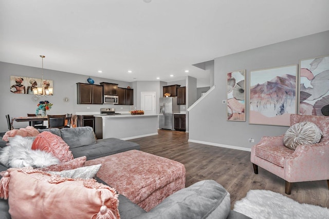 living room with baseboards, dark wood-type flooring, recessed lighting, and an inviting chandelier