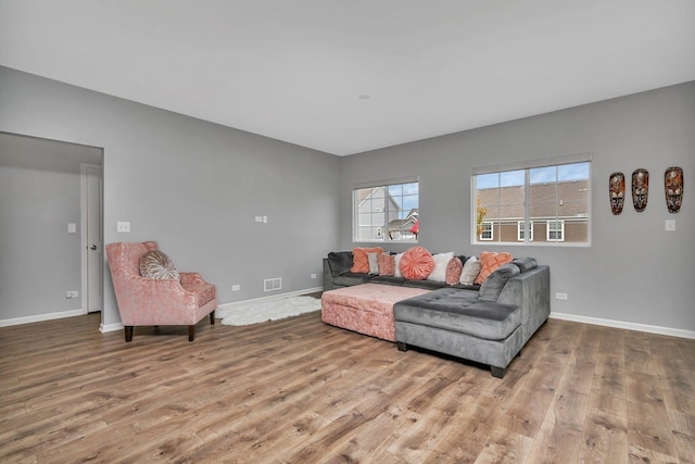 living area with visible vents, baseboards, and wood finished floors