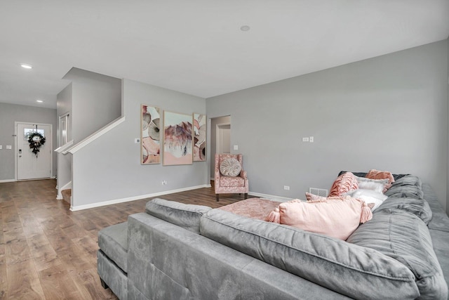 living area with recessed lighting, wood finished floors, visible vents, baseboards, and stairs