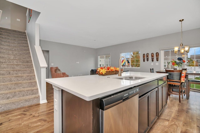 kitchen featuring dishwasher, light countertops, a sink, and light wood-style flooring