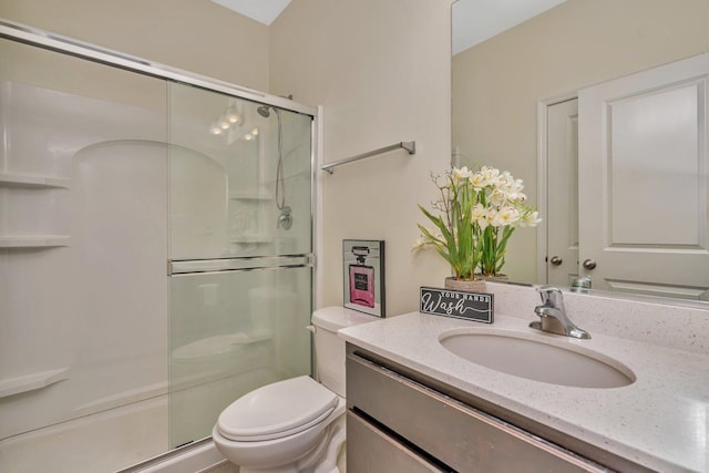 full bath with a stall shower, vanity, and toilet