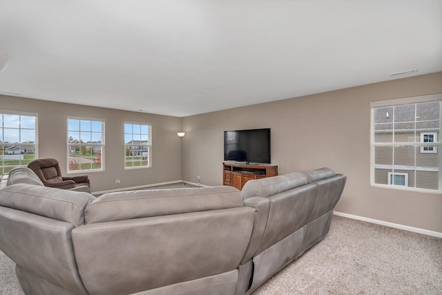 living area with light colored carpet, visible vents, and baseboards