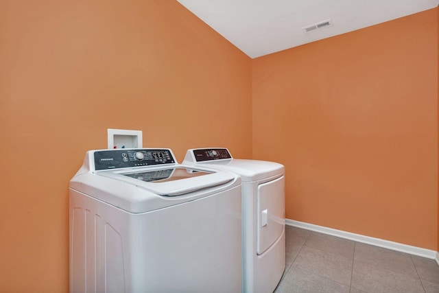 laundry room featuring laundry area, light tile patterned floors, baseboards, visible vents, and washing machine and clothes dryer