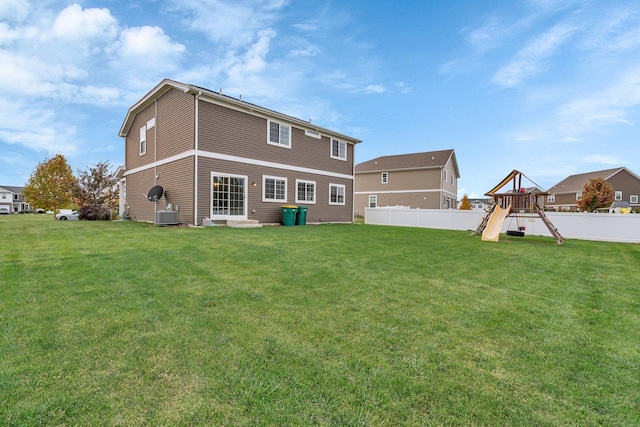 back of property with a yard, a playground, and fence private yard